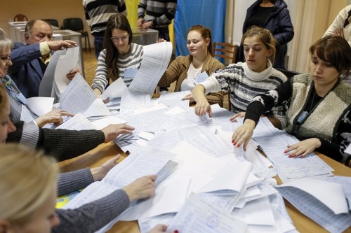 Members of a local electoral commission count ballots at a polling station after voting day in Kiev