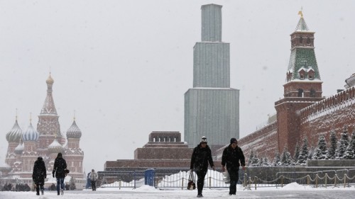People walk in the Red Square as it snows in central Moscow